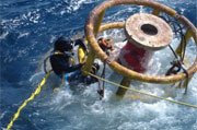 DIVERS WITH SUBSEA PRODUCTION BUOY DURING RECOVERY OPERATION